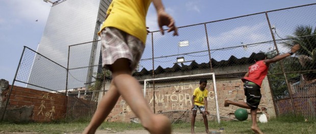 Children play soccer in the Vila Autodromo slum in Rio de Janeiro, Brazil, July 28, 2015. As sports arenas rise up around them and neighbours' houses are demolished, around 50 families remain in Vila Autodromo, a favela bordering the Olympic Park in Rio de Janeiro. About half of those refuse to leave the favela, which they describe as 